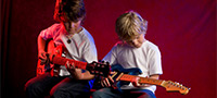Symbolfoto: Zwei Kinder die Gitarre lernen
