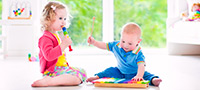 Symbolfoto: Zwei Kleinkinder üben an Musikinstrumenten